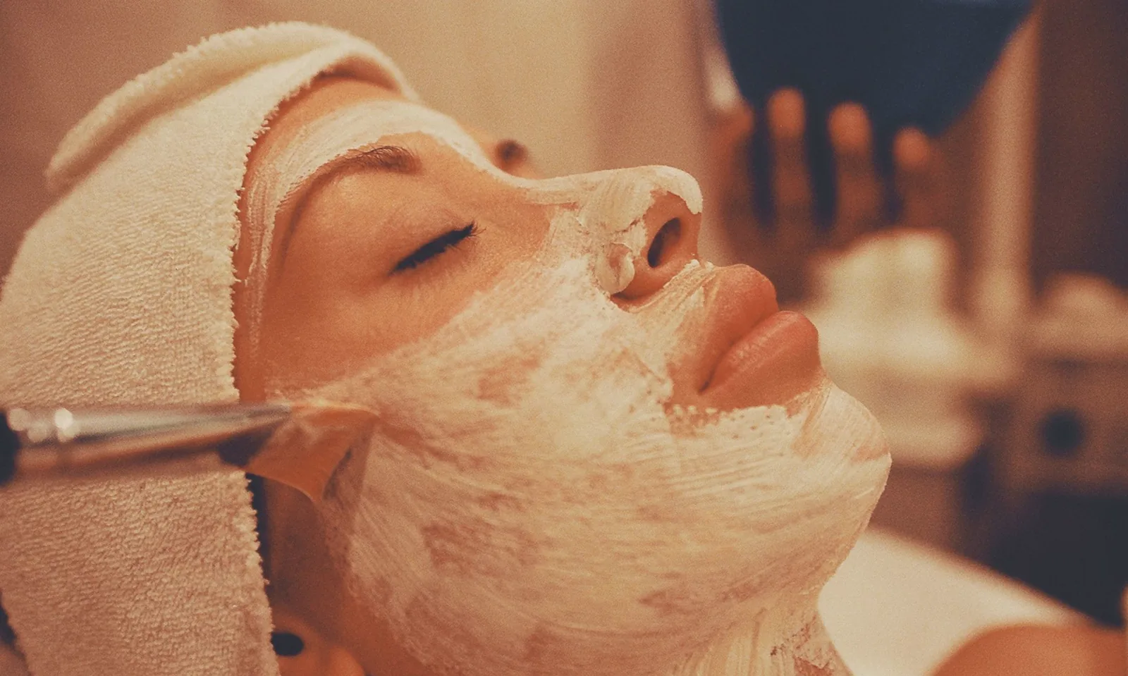 Masque appliqué au pinceau pendant un soin du visage en institut